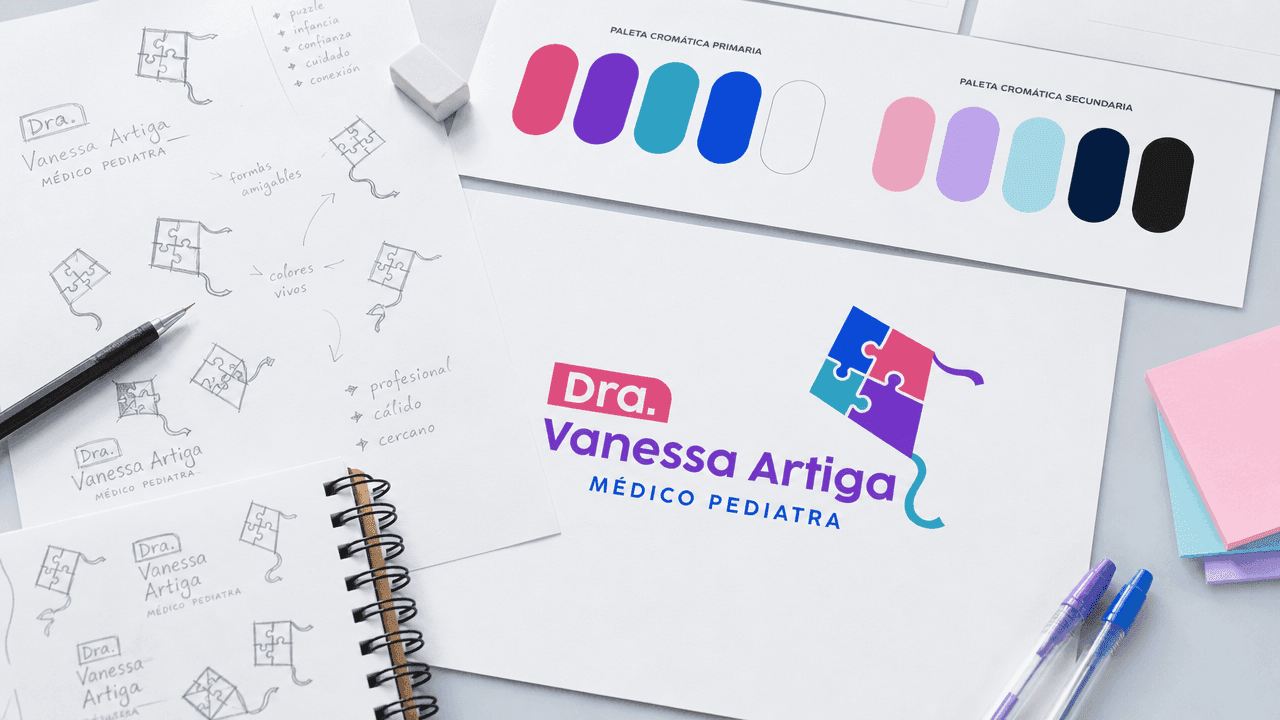 Brand board laid out on a desk: pencil logo sketches, the printed colour palette, and the final logo applied.